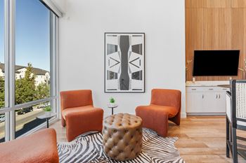 A living room with a zebra print rug and a large abstract painting on the wall.